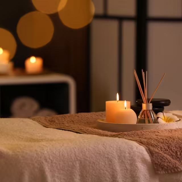 Spa candles and aromatherapy diffuser on massage table