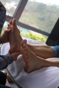 Foot massage session by a window.